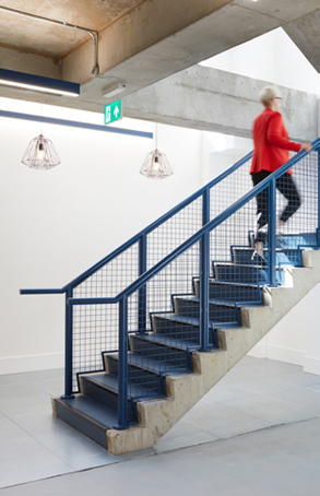 blue feature staircase leading up from lower ground level of Printworks House