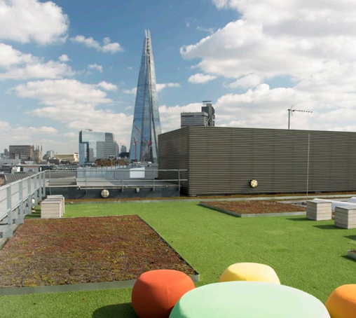 green and brown turfed rooftop terrace with seating and view of the Shard with a few clouds