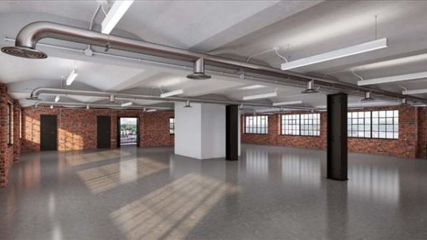 well lit open leasehold workspace with grey floors, brick walls and square French windows