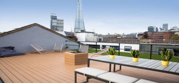 open roof terrace with beanbag wooden decking, deck chairs, table and bench, cool pot plans and rooftop view of the Shard